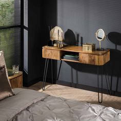 a bed room with a neatly made bed and a wooden desk in front of a window