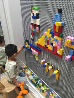 a young boy playing with legos on the wall