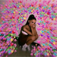 a woman sitting on the ground surrounded by hearts