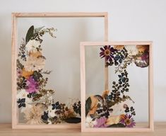 two wooden frames decorated with flowers and leaves