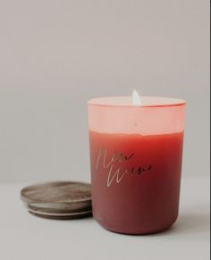 a red candle sitting next to a stack of coins