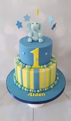 a blue and yellow cake with an elephant on top