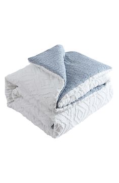 two blue and white blankets stacked on top of each other in front of a white background