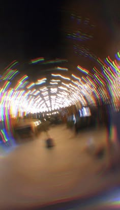 blurry photograph of an amusement park with people on the rides and lights in the background