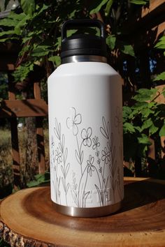 a white and black water bottle sitting on top of a tree stump