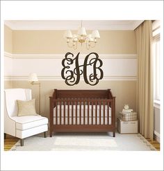 a baby's room with a crib, chair and chandelier