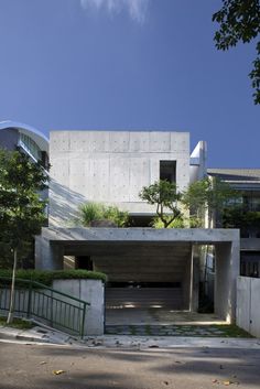 a concrete building with trees and bushes on the outside