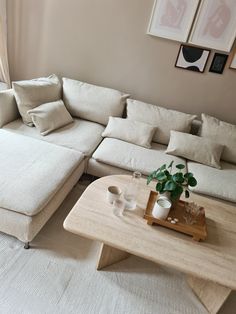 a living room with a couch, coffee table and pictures on the wall