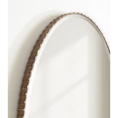 an arch shaped mirror hanging on the wall