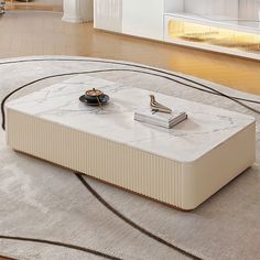 a marble coffee table on top of a rug in front of a white wall and floor