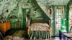 a bedroom with floral wallpaper and green painted walls, along with an antique bed