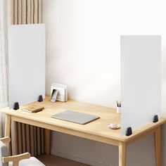 a wooden desk with two white canvases on it