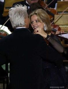 a man and woman standing next to each other in front of musical instruments on stage