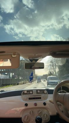 the inside view of a car driving down a street