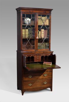 an old fashioned desk with books and a clock on it