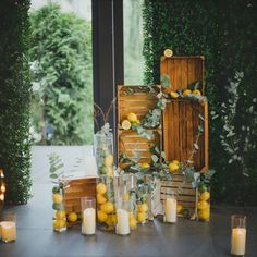 lemons and greenery are arranged on the table for an outdoor wedding ceremony with candles