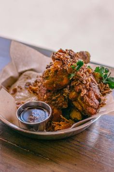 a plate with some food on top of it next to a small bowl of dipping sauce