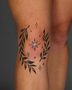 a woman's leg with a star and wreath tattoo on the side of her thigh