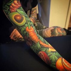 an arm tattoo with fruits and vegetables on it