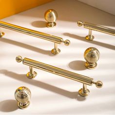 several brass colored handles and knobs on a white surface