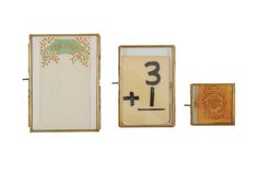 three framed objects with numbers on them and one in an open box next to it