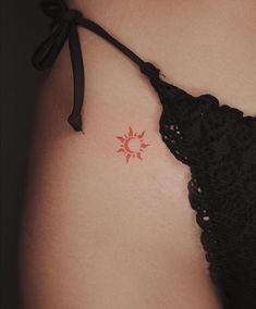 a woman's stomach with a small sun tattoo on it