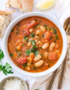 a white bowl filled with soup next to bread