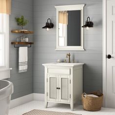 a bathroom with gray walls and white fixtures