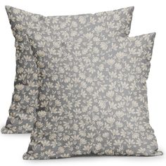 two grey and white pillows with floral designs on the front, one is made out of linen