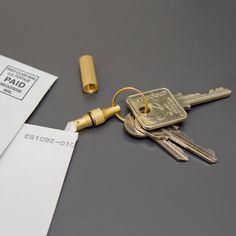 the keys are laying next to some mail and a pair of gold - plated scissors