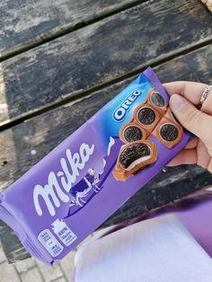 a person holding up a bag of milka cookies