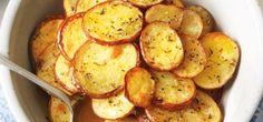 a white bowl filled with sliced potatoes on top of a table