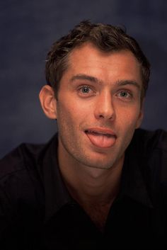 a man is making a funny face while wearing a black shirt and looking at the camera