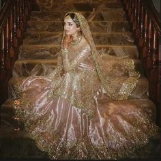 a woman in a wedding dress sitting on some stairs