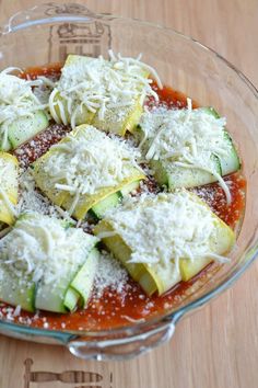 a glass bowl filled with zucchini and parmesan cheese