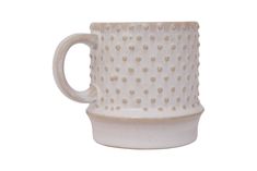 a white coffee cup with gold dots on the outside and inside, sitting in front of a white background