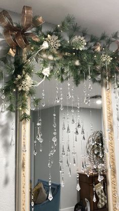 a mirror decorated with christmas decorations and hanging from it's sides in front of a wall