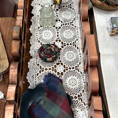 the table is covered with doily and other decorative items, including an old hat