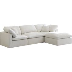 a white sectional couch with pillows on it's back and the seat folded out