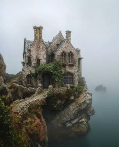 an old stone house sitting on top of a cliff