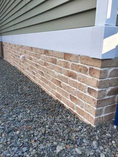 the corner of a house with a brick wall