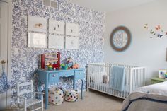 a baby's room with blue and white wallpaper