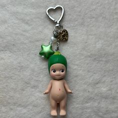 a little doll with a green hat on it's head is hanging from a key chain