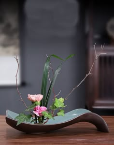 a vase with flowers and greenery in it on a table