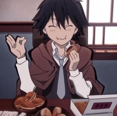 a man sitting at a table with food in front of him and holding his hands up