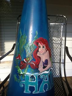 there is a large blue vase with a little mermaid on it's side and the letter h