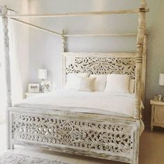 a white bed sitting in a bedroom on top of a floor next to a window