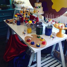 a table topped with lots of cakes and cupcakes