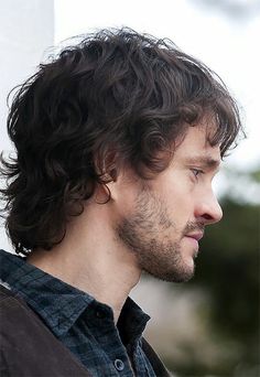 a close up of a person wearing a black shirt and looking off to the side