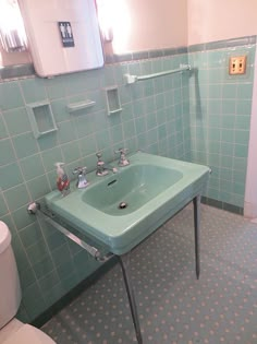 a green sink in a bathroom next to a toilet